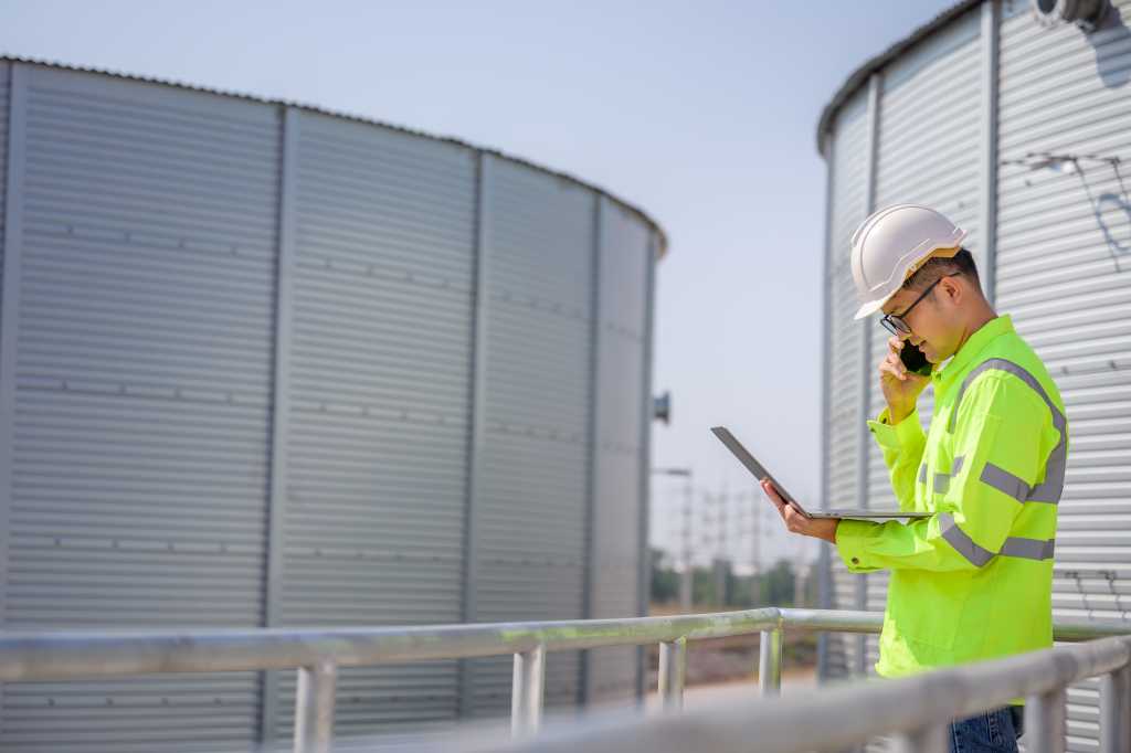 Asian male industrial engineer work through a laptop to Quality inspection in the engineering industry Utilities, water pipes and sewage pipes