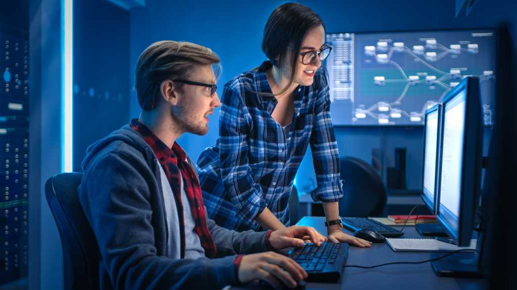 Male and Female Programmers Talking, Solving Problem, Using Computers, Doing High Five After Success. Software Development / Code Writing / Website Design / Database Architecture. Technical Department