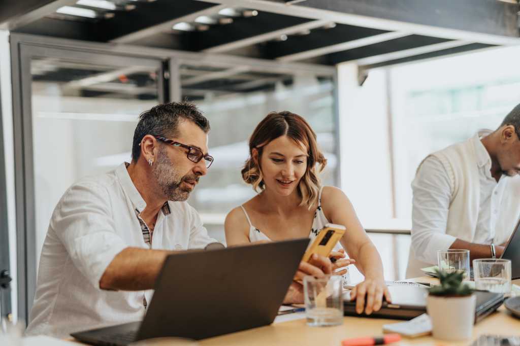 Collaborative business meeting in a modern office, where professionals of different ages and backgrounds share ideas, plan for growth, and solving problems together.