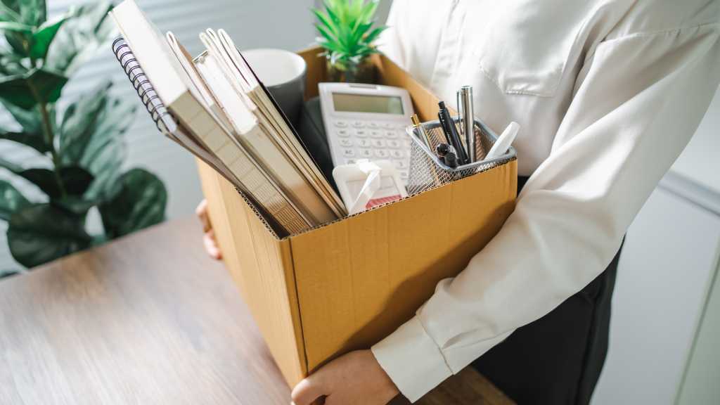 Business woman sending resignation letter and packing Stuff Resign Depress or carrying business cardboard box by desk in office. Change of job or fired from company.