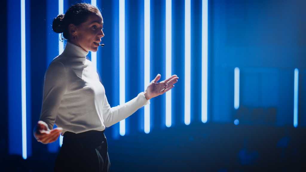 woman presenting in front of a conference