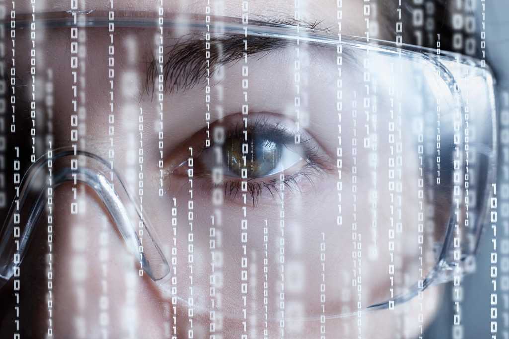 Close-up shot of an eye and eyewear with binary streams in the foreground.
