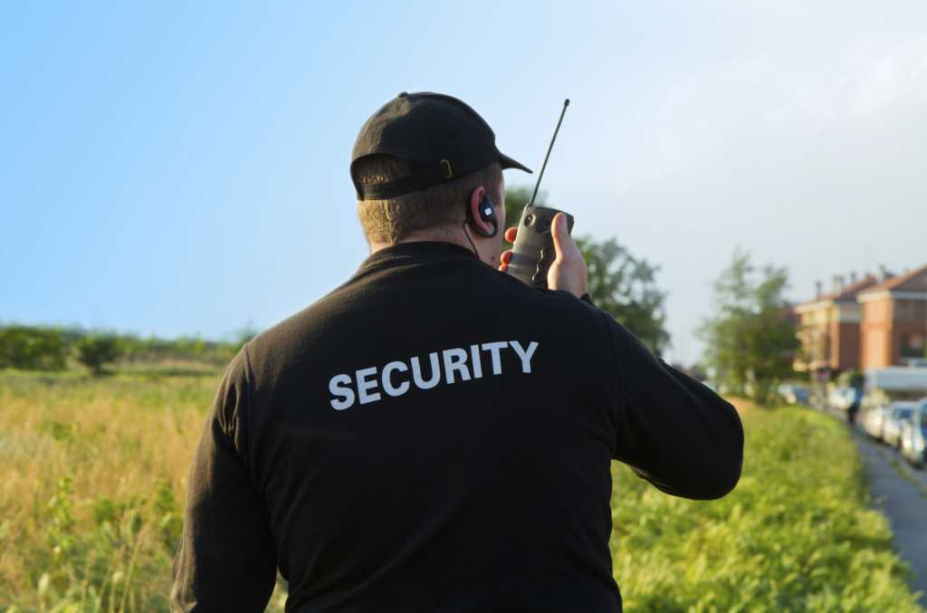 Male security guard in black jacket from behind